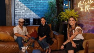 Bianca Comparato sentada no sofá com amigos