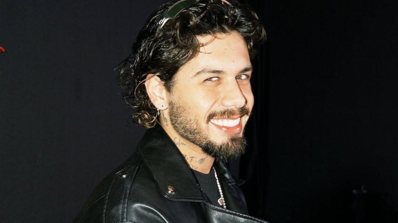 Foto mostra o cantor Zé Felipe. Homem branco, cabelo curto, sorrindo e usando roupa preta.