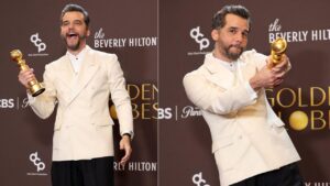 A foto mostra o ator Wagner Moura com terno branco e segurando a estatueta do Golden Globe.