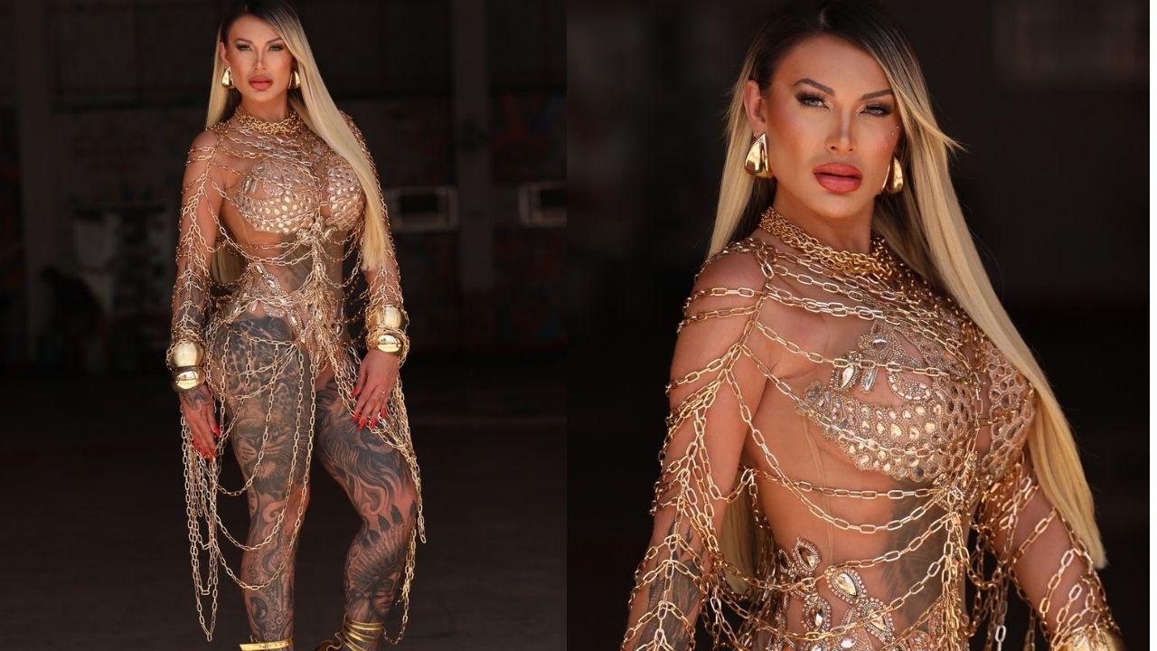 Andress Urach com fantasia de carnaval. Mulher branca, loira, cabelo liso longo, fantasia de correntes pelo corpo todo.