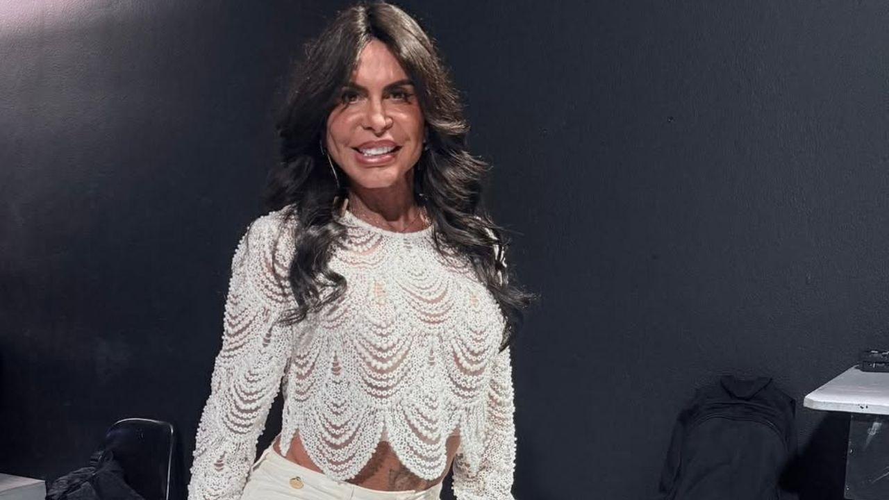 Gretchen. Mulher branca, cabelo liso longo e usando roupa branca.