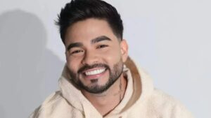 Yudi Tamashiro. Homem asiático, cabelo preto, sorrindo, usando moletom branco.