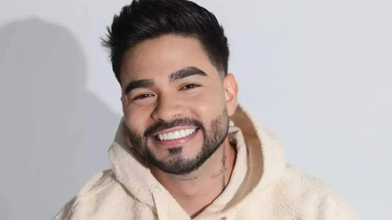 Yudi Tamashiro. Homem asiático, cabelo preto, sorrindo, usando moletom branco.