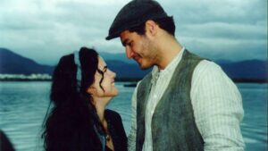 Ana Paula Arósio e Thiago Lacerda em cena da novela Terra Nostra. Eles estão de perfil e olhando para o rosto do outro.