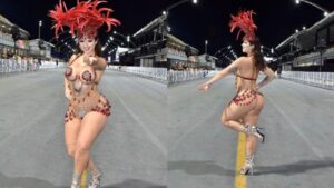 Mulher branca, cabelo castanho preso com fantasia de carnaval vermelha na avenida. É uma fantasia cheia de strass e curta com penas na cabeça.