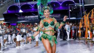Virginia. Mulher branca, loira, com fantasia de carnaval verde e plumas na cabeça.