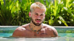 Cantor Zé Felipe. Homem branco, cabelo curto loiro, barba castanha. Dentro da piscina, com os ombros a mostra.