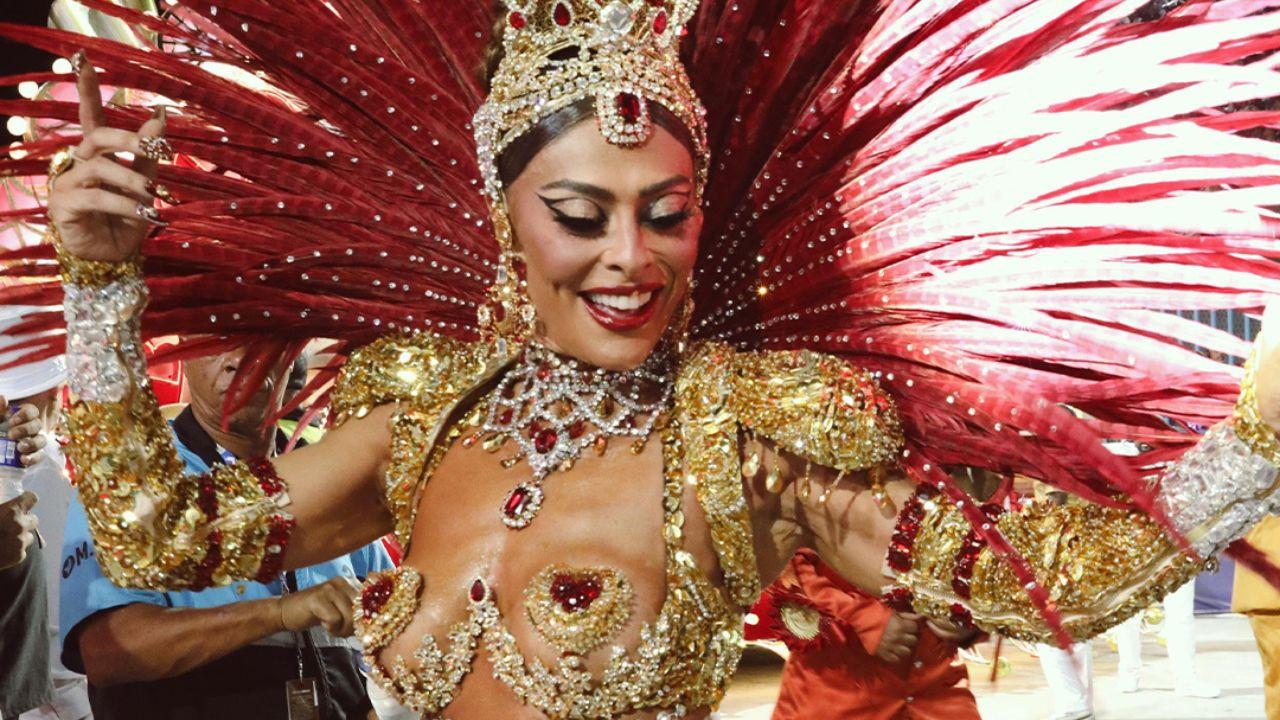 Juliana Paes com fantasia vermelha de carnaval cheia de brilho e plumas.