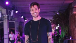 Dado Dolabella. Homem branco, cabelo curto castanho, com barba e usando camiseta preta.