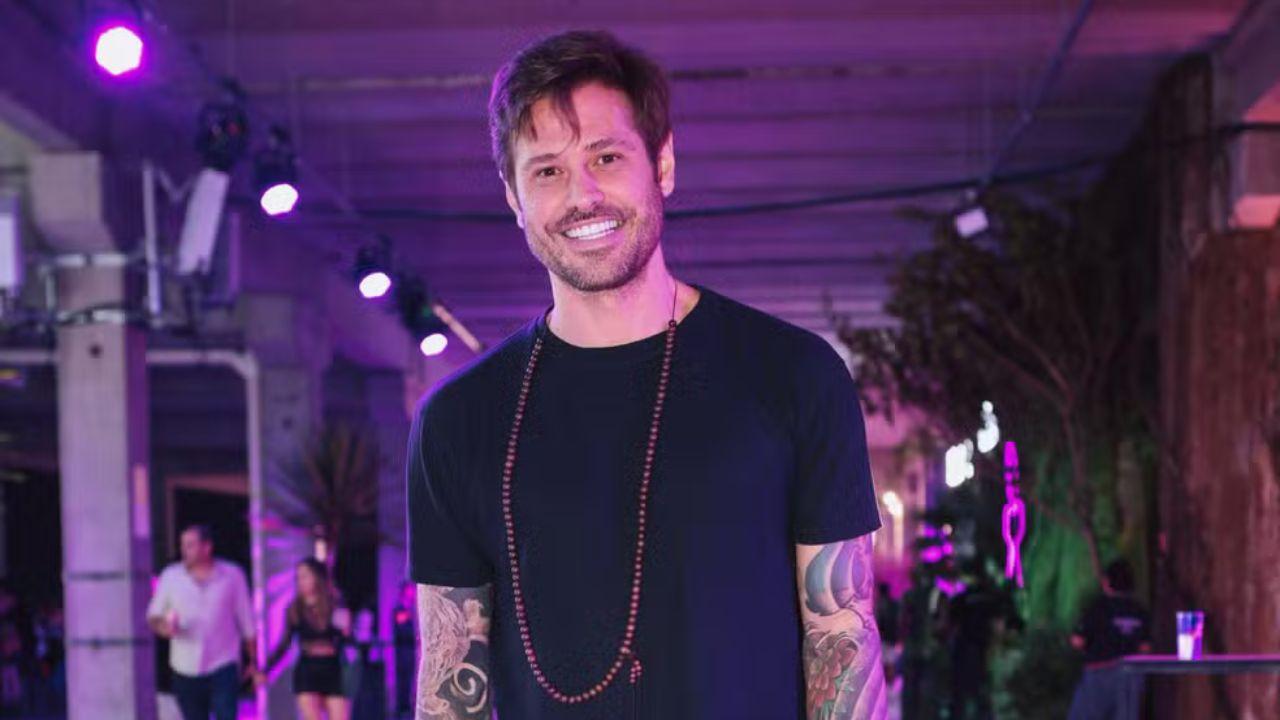 Dado Dolabella. Homem branco, cabelo curto castanho, com barba e usando camiseta preta.