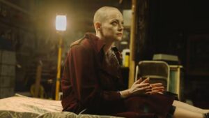 Emma Stone. Ela está em Bugonia, com visual careca e com a pele manchada.