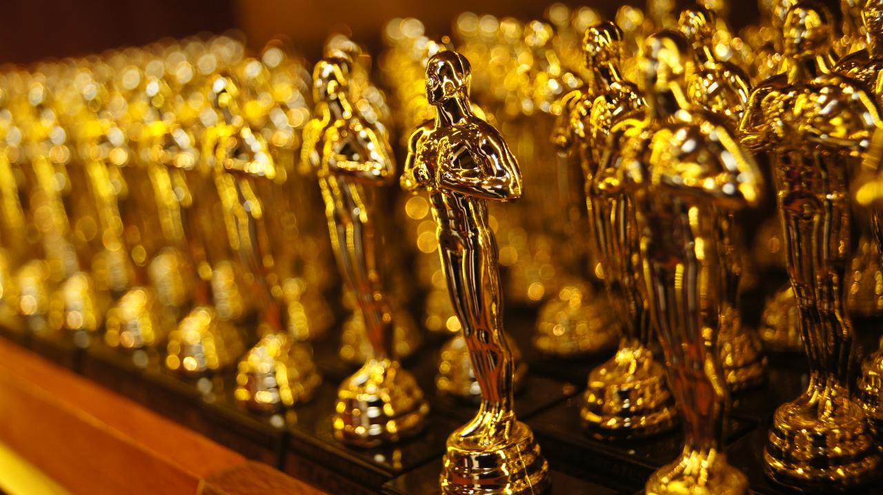 Foto mostra várias estatuetas do Oscar empilhados na mesa.