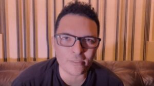 Leandro Lehart. Homem branco, cabelo castanho curto, usa óculos e veste camiseta preta.