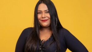 Chaiany do BBB. Mulher negra, cabelo liso, usando blusa preta e batom vermelho.