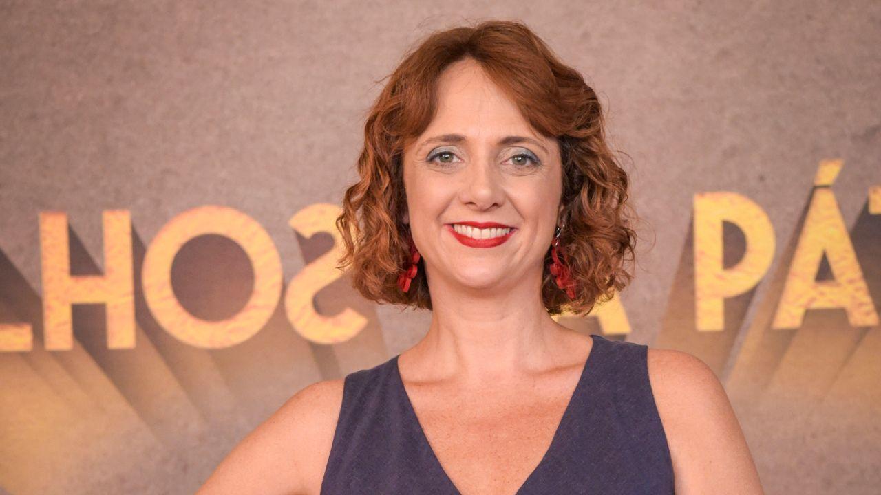 Atriz Letícia Isnard. Mulher branca, loira, cabelo loiro cacheado.