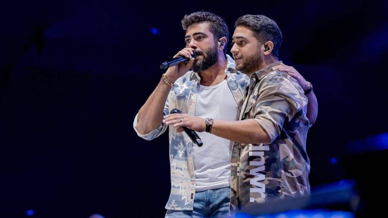 Dupla Henrique & Juliano no palco cantando.