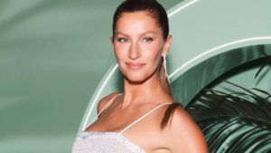 Foto mostra a modelo Gisele Bündchen. Mulher branca, loira, cabelo liso preso em um rabo de cavalo.