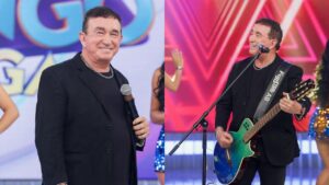 Amado Batista no palco com violão e microfone.