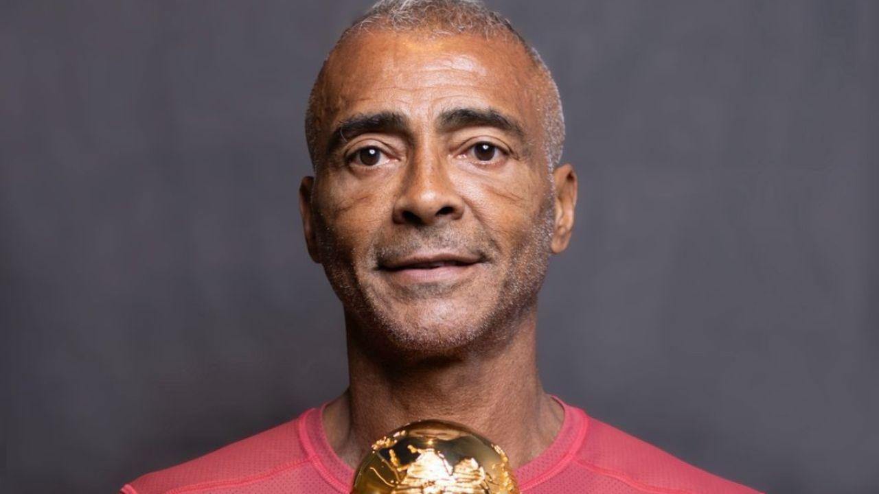 Romário na foto. Homem negro, cabelo raspado, usando camiseta rosa.