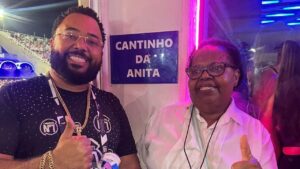 Dudu Nobre sua mãe Lucinha Nobre. Homem negro, cabelo cacheado curto, sorrindo e mulher negra, cabelo curto e sorrindo.