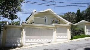 Fachada de uma mansão. Pintura branca, com pilastras gregas.