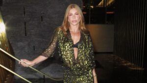 Grazi Massafera com vestido verde estampado em pé, perto de um corrimão.